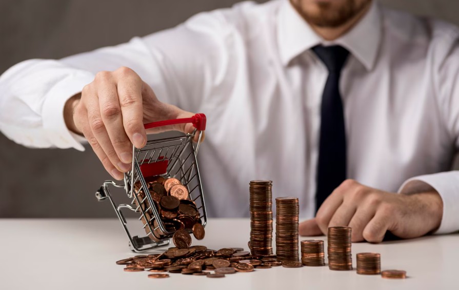 Business professional tipping coins from a small shopping cart with stacked coins symbolizing wealth succession