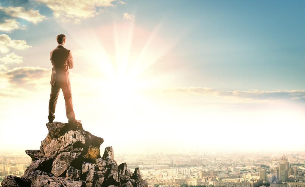 Young,Businessman,Standing,On,Edge,Of,Rock,Mountain,And,Looking 