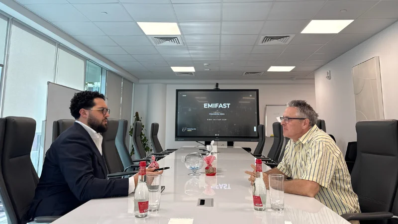 Diverse team of entrepreneurs attentively watching a business presentation on a large screen in a conference room
