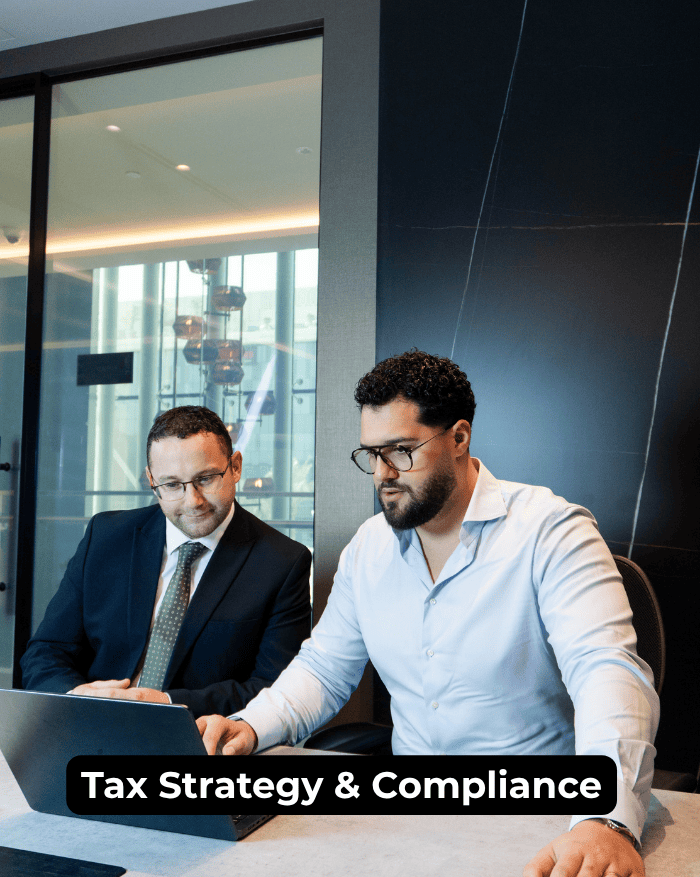 Corporate tax consultants discussing corporate tax strategy and compliance solutions on a laptop in a modern office