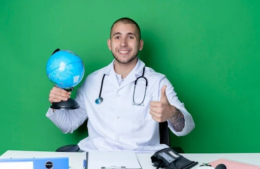 Smiling doctor holding a globe and giving a thumbs-up