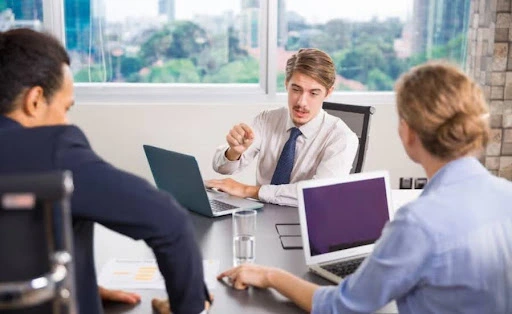Business consultant discussing strategy with clients during a professional corporate advisory and dmcc free zone company setup meeting
