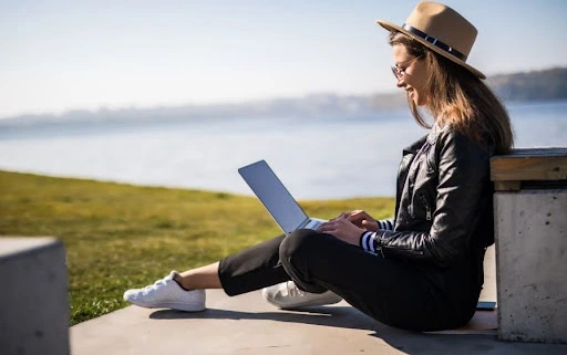 Female entrepreneur working on a laptop outdoors, representing remote business setup and digital entrepreneurship