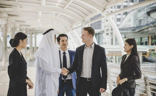 Business professionals shaking hands during a corporate partnership meeting in Dubai, discussing company setup, international business expansion and permanent establishment in uae