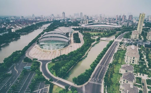 Aerial view of a modern city with highways, river, and large commercial buildings showcasing urban infrastructure and business district development.