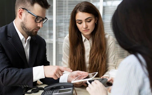 A professional man explaining details to  female colleagues regarding corporate bank account dubai