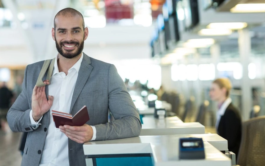 businessman standing at check-in counter with passport and boarding pass