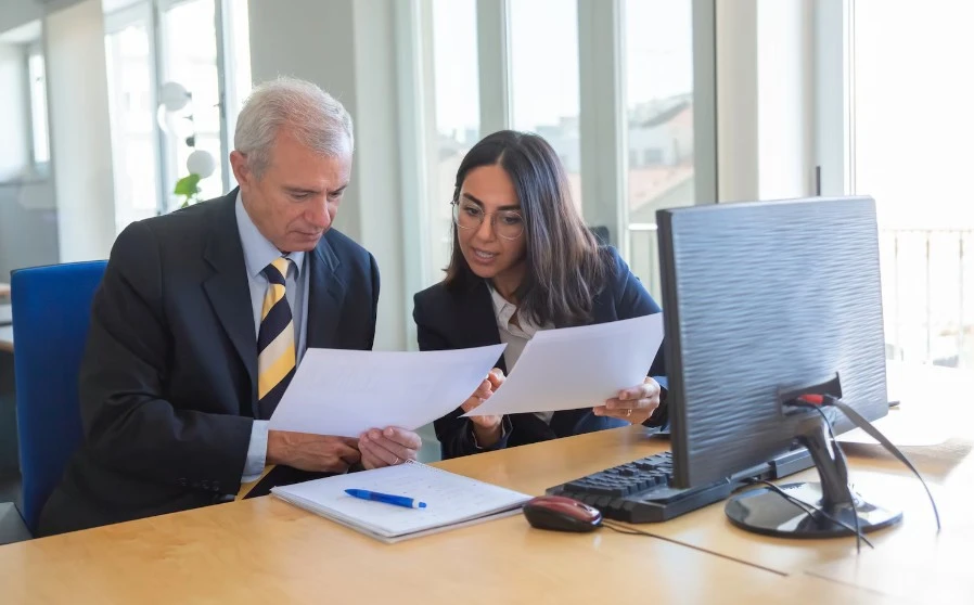 Female professional explaining document details to client at workplace