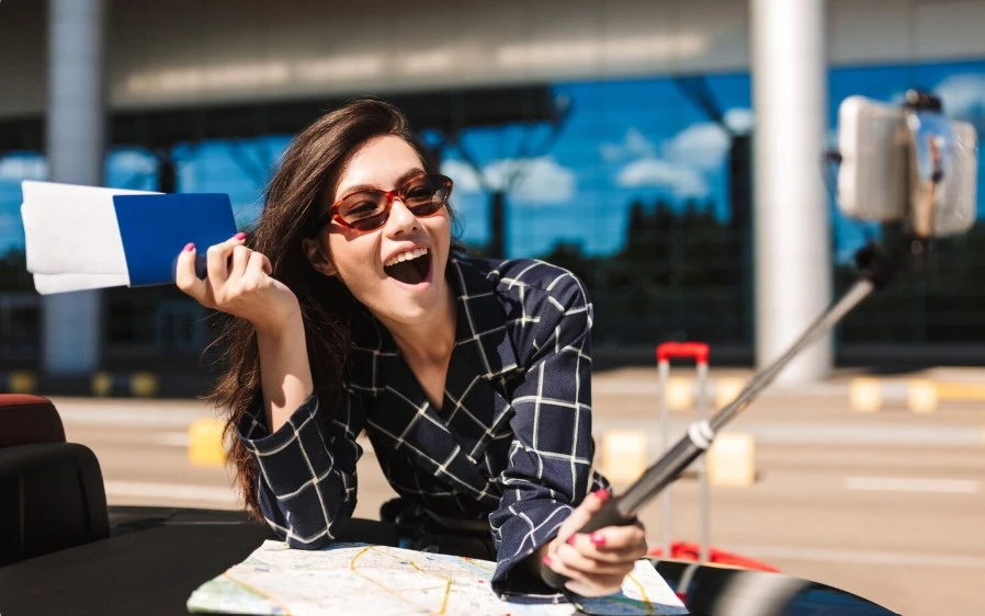 Joyful girl in sunglasses holding visa and passport